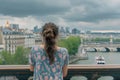 female with a french twist admiring city views from a bridge