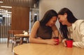 Female friends drink coffee or tea from red cups with straws Royalty Free Stock Photo