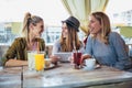 Female friends enjoying in conversation and drinking coffee in cafe Royalty Free Stock Photo