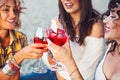 Female friends with glass of rose wine on summer beach picnic