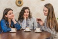 Female friends having a coffee together. Three women at cafe drinking, talking, laughing and enjoying their time Royalty Free Stock Photo