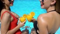 Female friends having fun at poolside and drinking cocktails, summer pool party Royalty Free Stock Photo