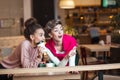 Female friends having lunch at mall cafe laughing and smiling after shopping Royalty Free Stock Photo