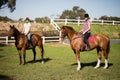 Female friends horseback riding during sunny day