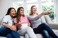 Female friends with remote and popcorn watching movie Royalty Free Stock Photo