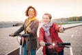 Female friends ride modern rented electric scooters through the streets of the city. Transport and lifestyle and friendships