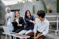 female friends shoo away male friends using a laptop while sitting