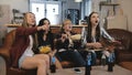 Female friends watch TV show with snacks at home. Young European girls enjoying romantic comedy slow motion 4K.