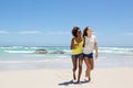 Female friends smiling and walking on the beach together Royalty Free Stock Photo