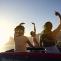 Female Friends Standing Up Through Sun Roof Car And Dancing On Road Trip Through Countryside Royalty Free Stock Photo