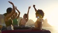 Female Friends Standing Up Through Sun Roof Car And Dancing On Road Trip Through Countryside Royalty Free Stock Photo