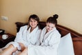 Female friends wearing white bathrobes relaxing in a hotel Royalty Free Stock Photo