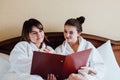 Female friends wearing white bathrobes relaxing in a hotel Royalty Free Stock Photo