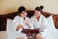 Female friends wearing white bathrobes relaxing in a hotel Royalty Free Stock Photo