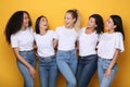 Five Mixed Girls Laughing Posing On Yellow Background In Studio