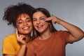 Female friendship. Two happy multi-ethnic teen girls friends having fun while applying face mask Royalty Free Stock Photo