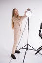 Female gaffer works with constant light in studio