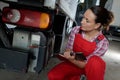 female garage worker inspecting rear lights on heavy goods vehicle