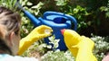 Female gardener adding fertilizer for plants to watering can