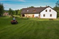 Female gardener driving a lawn tractor and mowing grass Royalty Free Stock Photo