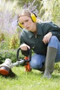 female gardener experiencing problem with strimmer Royalty Free Stock Photo