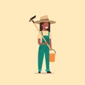 Female gardener holding hoe and bucket african american country woman working in garden gardening eco farming concept
