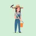 Female gardener holding hoe and bucket country woman working in garden gardening eco farming concept full length