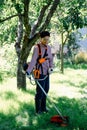 Female gardener mows the grass in garden using string trimmer. Garden work concept Royalty Free Stock Photo