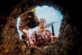 Female gardener planting. View from underground.