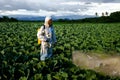 Female gardener in a protective suit and mask spray Insecticide and chemistry Royalty Free Stock Photo