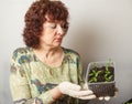 A female gardener shows a pot with sprouts after a pick