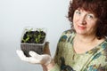 A female gardener shows a pot with sprouts after a pick