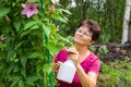 Female gardener taking care of plants in summer garden, spraying a plant with pure water Royalty Free Stock Photo