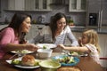 Female gay couple and daughter having dinner in their kitchen Royalty Free Stock Photo