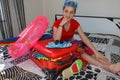 Female Getting Ready For Traveling. young beautiful woman, red suitcase, sitting, waiting, summer vacation, colorful, traveling ar Royalty Free Stock Photo