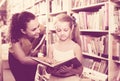 Female with girl in school age looking in open book