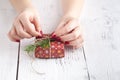 Female give present wrapped craft paper on aged wooden table, holiday gift box. Copyspace from corner