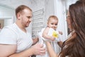 Female giving baby in blanket to its father Royalty Free Stock Photo