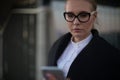 Female in glasses professional manager received notifications on cellphone Royalty Free Stock Photo