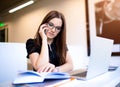 Female in glasses skilled advertiser reading information from textbook during mobile phone conversation