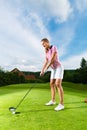 Female golf player on course doing golf swing Royalty Free Stock Photo
