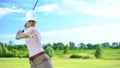 Female golf player hitting ball with club at course, training and sport, hobby Royalty Free Stock Photo