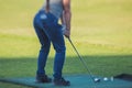 Female golfer girl player practicing and training golf swing on driving range practice, woman playing on golf course, golf ball at Royalty Free Stock Photo