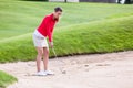 Female golfer hitting golf ball on bunker Royalty Free Stock Photo