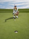 Female Golfer Lining Up A Putt