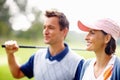 Female golfer smiling. Closeup of woman smiling and looking away with man holding a golf club. Royalty Free Stock Photo