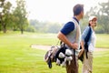 Female golfer smiling and looking at man. Focus on female golfer smiling and looking at man. Royalty Free Stock Photo