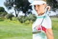 Female golfer standing holding her club smiling at camera Royalty Free Stock Photo