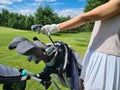 Female golfer stands next to golf bag and clubs Royalty Free Stock Photo