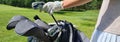 Female golfer stands next to golf bag and clubs Royalty Free Stock Photo